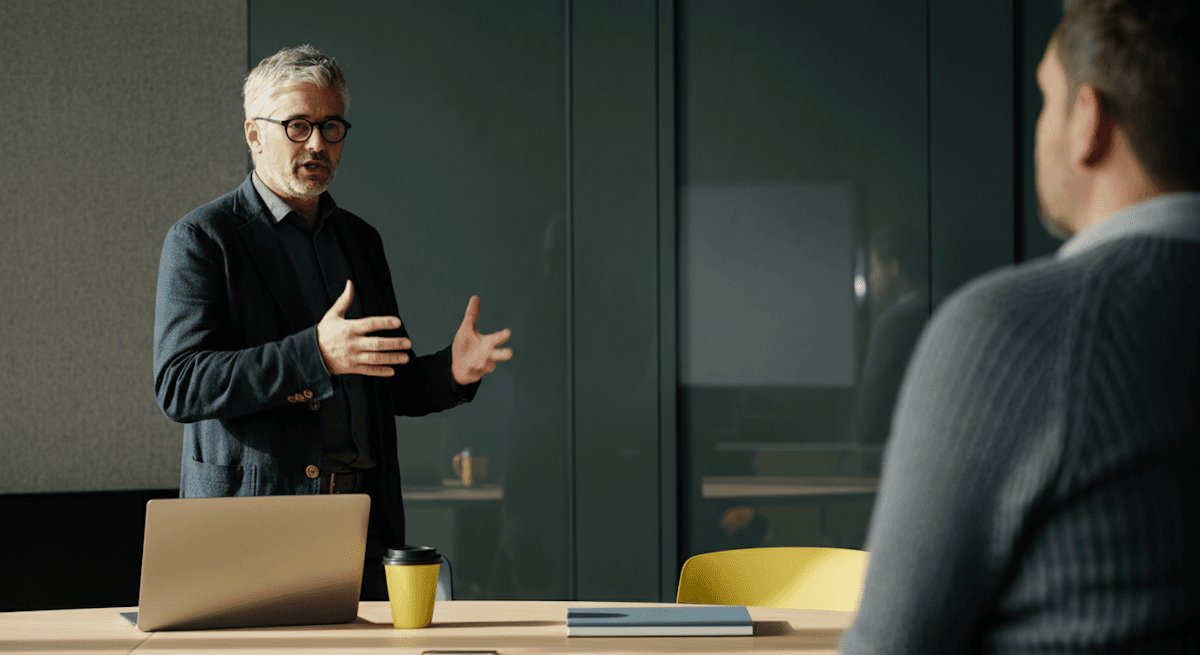 A consultant presenting across a table in a meeting room