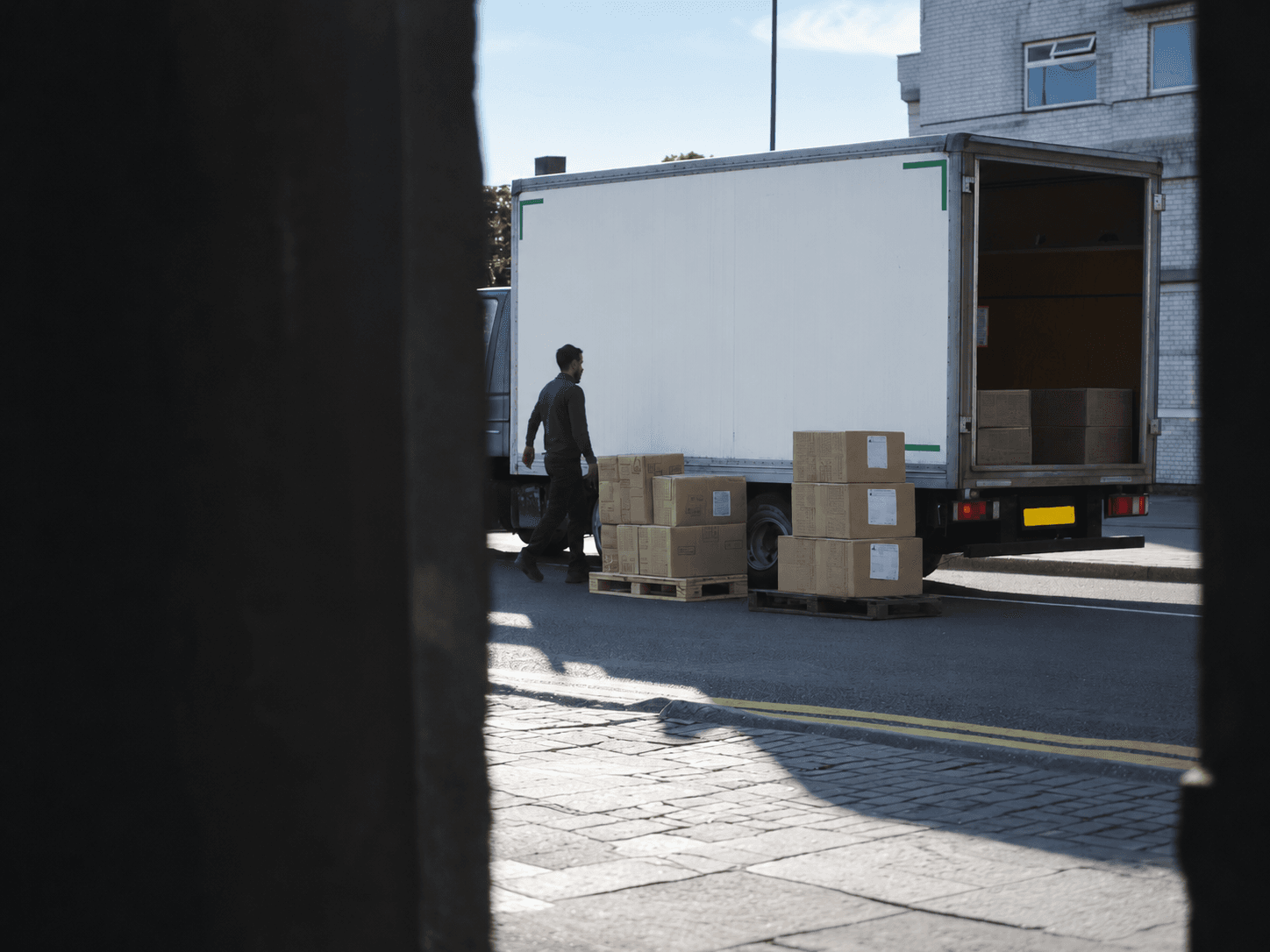 Delivery truck and boxed pallets on a city street